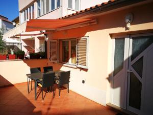 eine Terrasse mit einem Tisch und Stühlen sowie ein Gebäude in der Unterkunft Marko Apartment in Pula