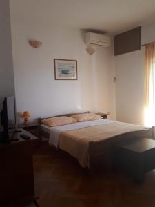 a bedroom with a large bed and a window at Apartments Ivanka in Starigrad