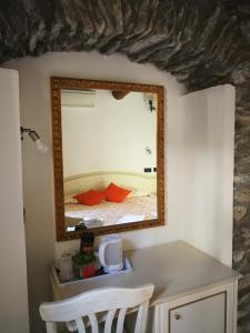a mirror on a wall with a bed in a room at Locanda Ca Dei Duxi in Riomaggiore