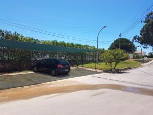 een auto geparkeerd op een parkeerplaats naast een straat bij Remodelada Villa nos Jardins da Balaia in Albufeira