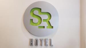 提比里斯的住宿－Hotel S.R，挂在墙上的酒店标志