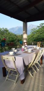 a long table with chairs sitting on a patio at Casa san salvadore in Favalello