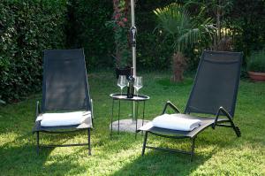 two chairs and a table in the grass at Casa Rossa Apartment in Portorož