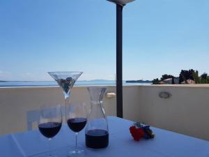 zwei Gläser Rotwein auf dem Tisch in der Unterkunft Apartments Sea Reflections in Žman