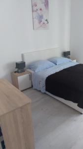 a bedroom with a bed with a black and white blanket at Danijel in Novi Vinodolski