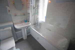 une salle de bain avec un lavabo, une baignoire et des toilettes dans l'établissement Easdale House Apartments, à Inverness 25 autres photos