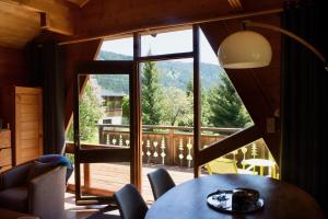 een eetkamer met een tafel en een groot raam bij Le Petit Skieur B&B in Le Sappey-en-Chartreuse