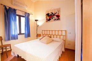 a bedroom with a white bed and a window at Agriturismo Sicomoro in Capalbio