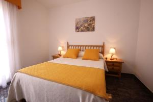 a bedroom with a bed and two lamps on tables at Hostal San Roque in Portonovo