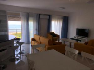 a living room with a couch and chairs and a television at Alba Luxury Apartment in Durrës