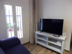 una sala de estar con TV de pantalla plana en un armario blanco en El Almizcate, en Vejer de la Frontera