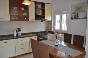 a kitchen with a wooden table and a dining room at Apartman Ika Umag in Umag