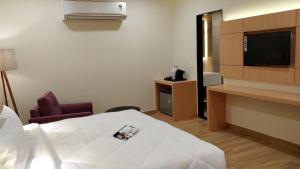 a hotel room with a bed and a television at 10 Park Street Bed & Breakfast in Gorakhpur