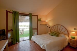 a bedroom with a bed and a large window at Agriturismo Sicomoro in Capalbio