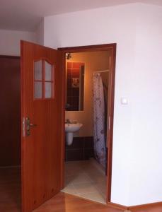 a bathroom with a door leading to a sink at Pokoje Kasztanowa in Wilkasy