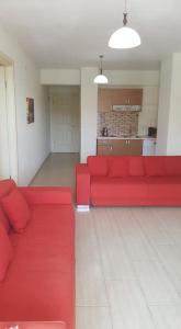 a living room with a red couch and a kitchen at Aydeniz Apart Hotel in Datca
