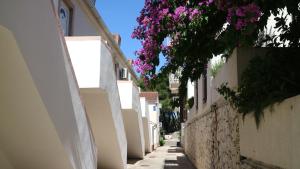 an alley with white buildings and purple flowers at Apartment Ena - Lavica in Podstrana