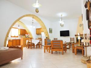 a living room with an archway and a table and chairs at Traditional Cretan Villa in Rodhopós