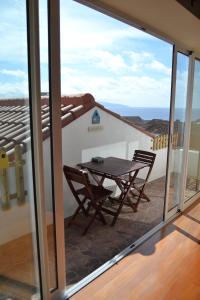 a table and chairs on the balcony of a house at Matriz Guest House in Ribeira Grande +33 photos