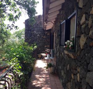 ein Steingebäude mit einem Fenster und einer Terrasse in der Unterkunft Aprisa apartment in Piedimonte Etneo