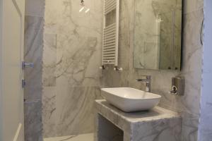 łazienka z białą umywalką i lustrem w obiekcie FLOS Guest House w mieście Lucera +37 zdjęć