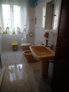a bathroom with a sink and a toilet and a mirror at B&B Vista Fiume in Bosa