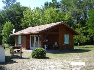 a small log cabin with a table and a bench at Chalet Saint Julien en Born in Saint-Julien-en-Born