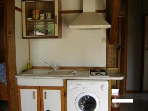 a kitchen with a sink and a washing machine at Chalet Saint Julien en Born in Saint-Julien-en-Born