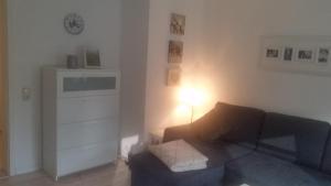 a living room with a couch and a clock on the wall at Ferienwohnung Jesper in Braunlage +18 photos