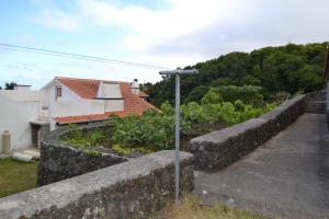 a stone retaining wall next to a house at Adega Mendes in Porto Martins