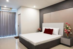 a bedroom with a white bed with a red pillow at DB Plus 5 in Bangkok