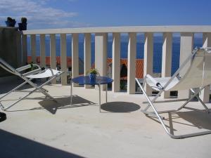 two chairs and a table on a balcony with the ocean at Apartman Lavanda in Sutivan