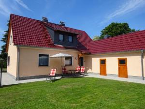 una casa con techo rojo, mesa y sillas en Ferienhaus Oberlausitz, en Malschwitz