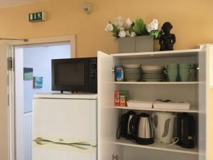 a kitchen with a refrigerator and a tv on a shelf at Eurostopas in Bremen
