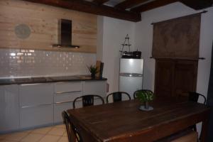 a kitchen with a wooden table and a refrigerator at Le Thuria in Sainte-Foy-Tarentaise