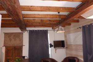 a room with wooden ceilings and a curtain and a television at Le Thuria in Sainte-Foy-Tarentaise
