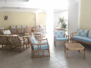 une chambre avec des chaises, des tables et un canapé dans l'établissement Hotel Castelsardo Domus Beach, à Castelsardo