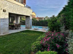 un patio avec une table et des chaises dans une cour dans l'établissement House Mia, à Ližnjan