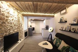 a living room with a couch and a tv at GregBnb-com - T2 Ancien et moderne - PARKING INCLUS - 15min Gare in Toulon