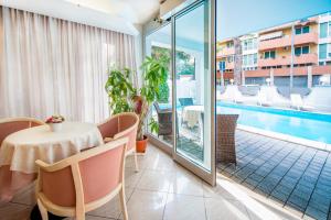 a dining room with a table and a swimming pool at Hotel Royal Plaza in Rimini