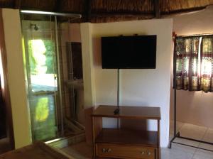 a living room with a flat screen tv on the wall at Lynns Guest House in Bulawayo