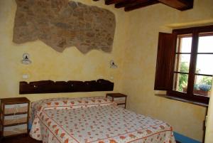 1 dormitorio con cama y ventana en La Mulattiera, en Scarlino