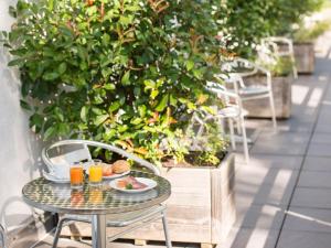 einen Tisch mit einem Teller Essen und zwei Gläsern Orangensaft in der Unterkunft viavelo hotel in Freiburg im Breisgau