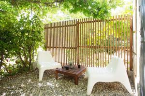 two white chairs and a coffee table in front of a fence at GregBnb-com - Studio CLIMATISÉ - Terrasse & parking privé in Toulon