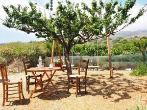 una mesa y sillas bajo un árbol en un patio en Traditional Cretan Villa, en Rodhopós