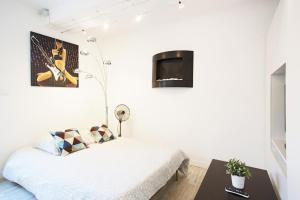 a bedroom with a bed and a tv on the wall at GregBnb - Studio moderne - Coin nuit - CLIMATISÉ in Toulon