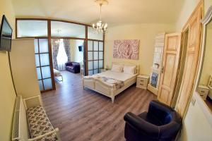 Un dormitorio con una cama y una silla en una habitación. en La Maisonnette, en Brasov