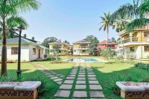 a backyard with a pool and palm trees and houses at Beach Retreat Villa in Varca