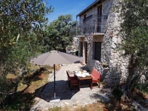 a table with an umbrella in front of a building at Holiday Home Strpuncina in Luka
