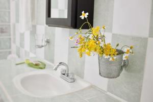 a bathroom sink with a bucket with flowers in it at CASA FRIDA FULL APARTMENTS holbox in Holbox Island